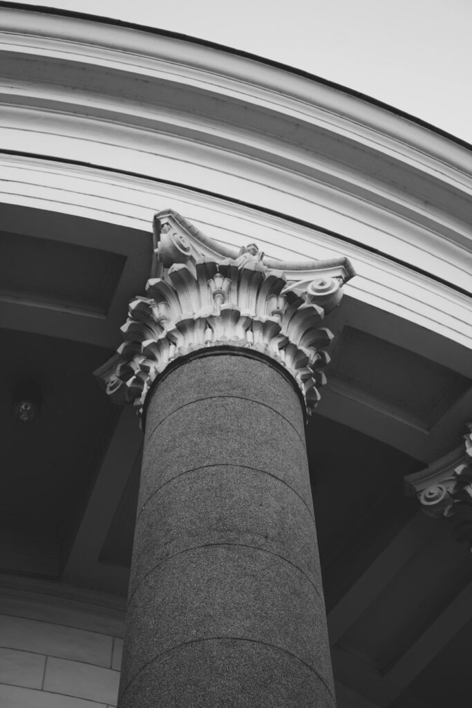 Close-up of a classic architectural column in black and white, highlighting intricate details.